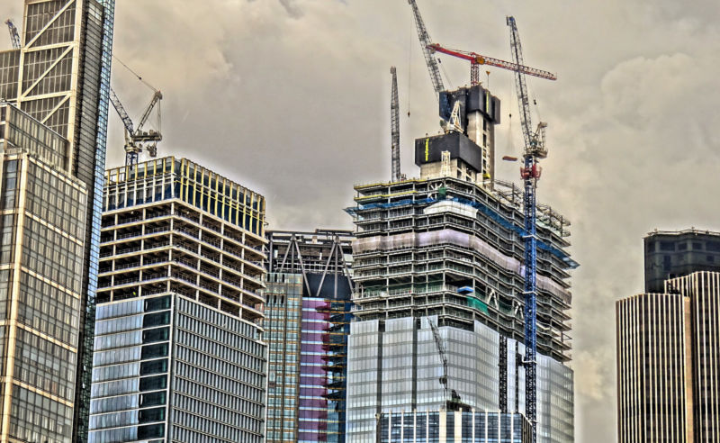 Stylized image of glass skyscraper under construction.