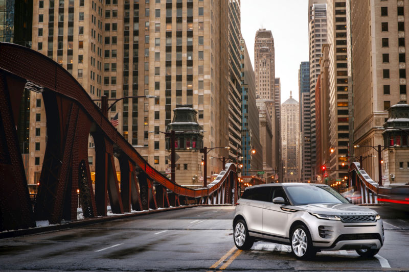 Promotional image of an automobile by itself on a metropolitan bridge.