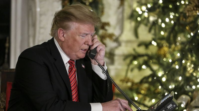 President Donald Trump speaks into a telephone.