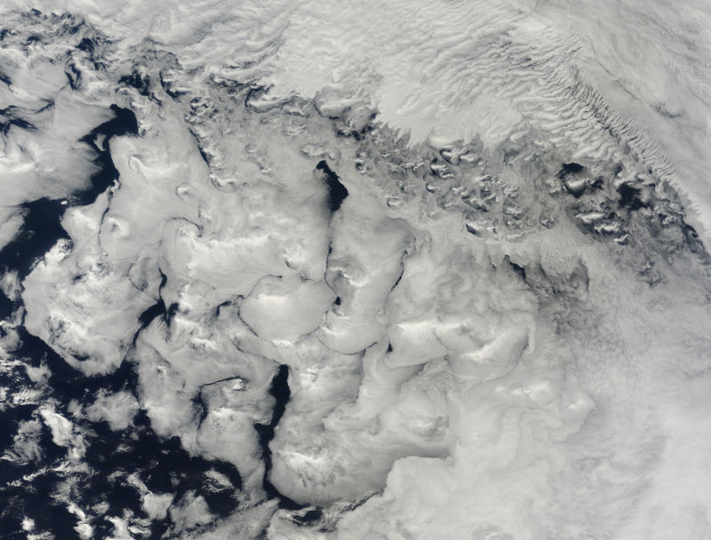 Stratocumulus clouds, like those in the lower two-thirds of this image, are common over the oceans.