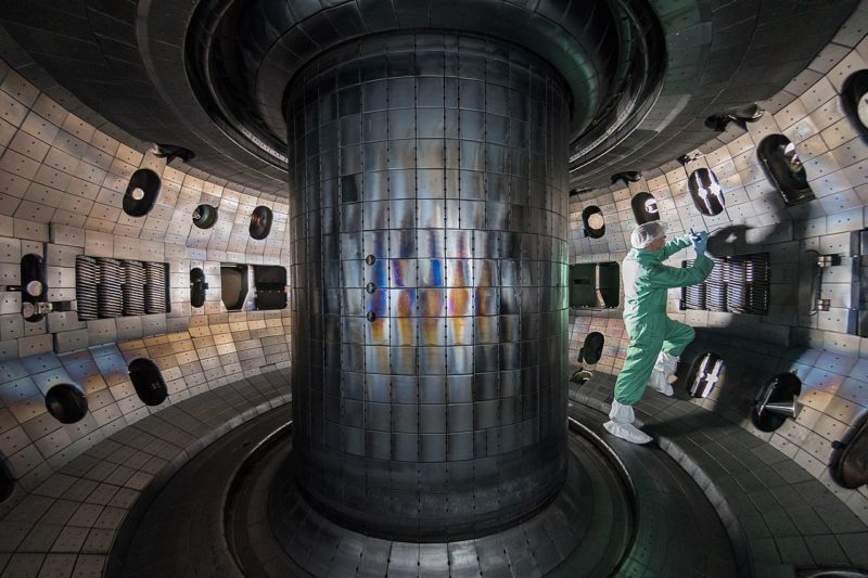 Image of a room with metallic tiles and a large central pillar.