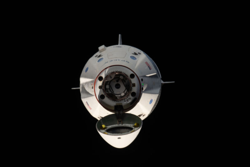 With its nose cone open, Dragon reveals its docking mechanism while approaching the station's Harmony module.