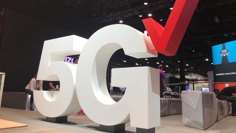 Un logotipo gigante de Verizon 5G en una sala de exposiciones.