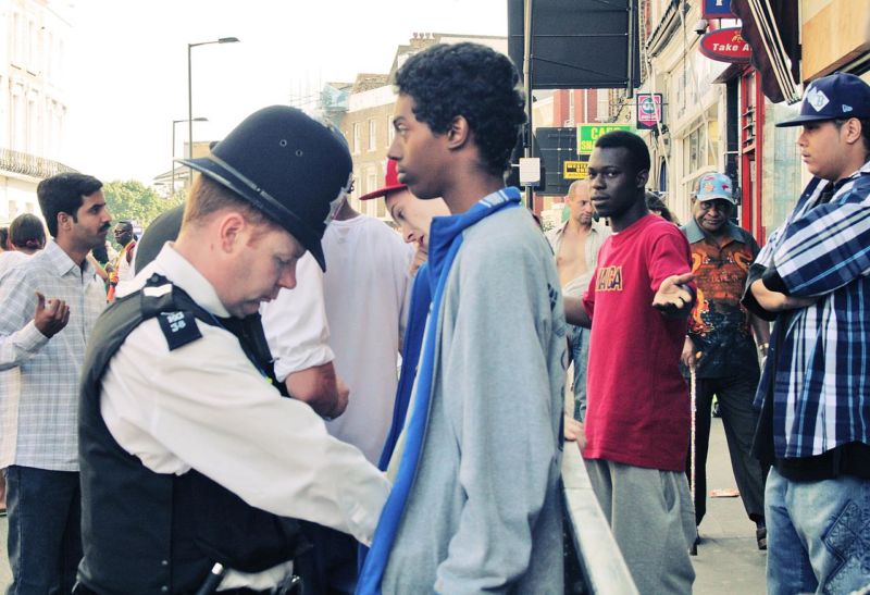 Image of the police searching a young male minority.