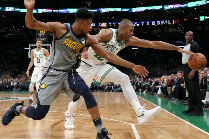 Boston Celtics' Al Horford and Indiana Pacers' Thaddeus Young chase a ball out of bounds during a March game. A new study found that a self-centered bias in time perception might affect how each perceives who touched the ball last.