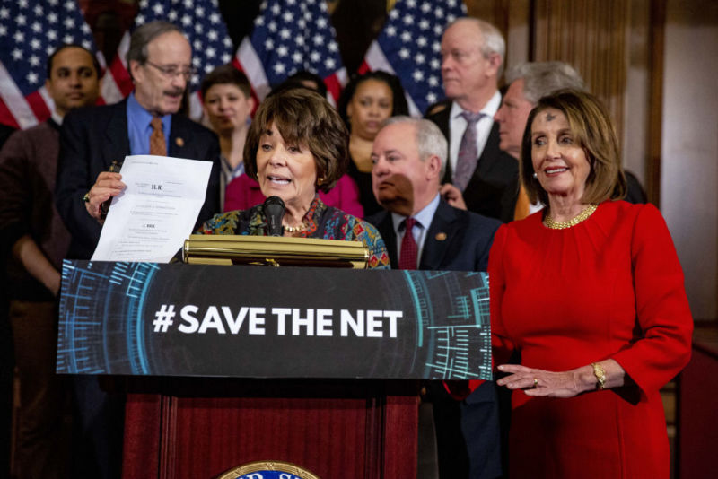 Rep. Anna Eshoo (D-Calif.) parla in piedi dietro un podio e tiene una copia cartacea di un disegno di legge sulla neutralità della rete durante una conferenza stampa, mentre la presidente della Camera Nancy Pelosi (D-Calif.) e altri democratici guardano.