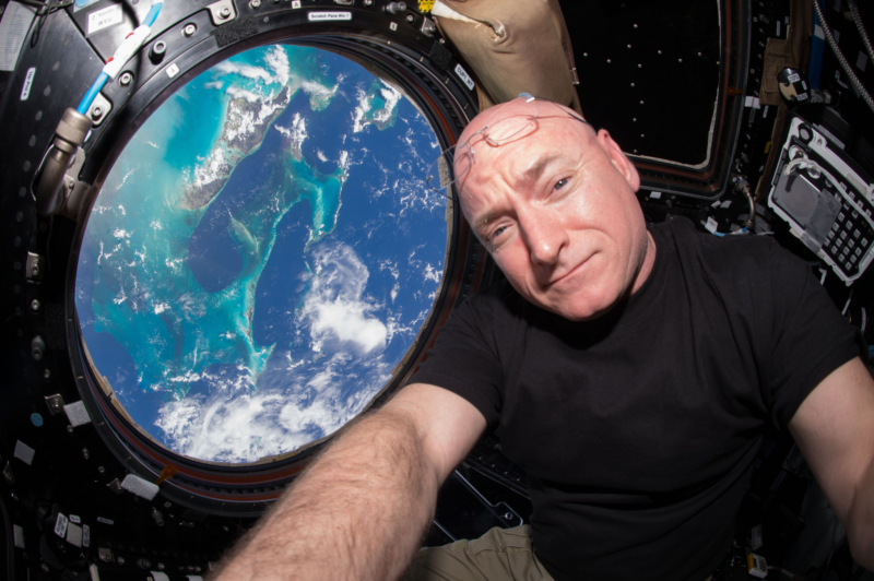 Image of an astronaut with Earth behind him in a window.