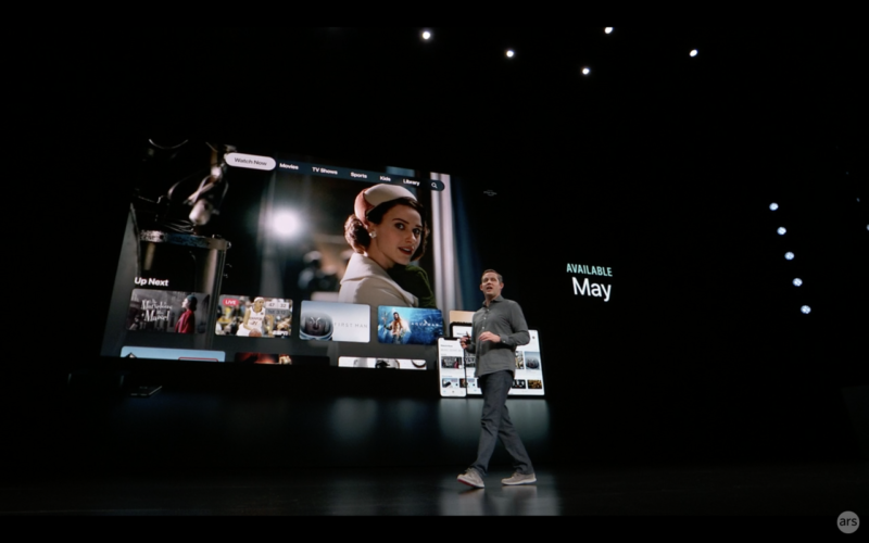 A man walks past a giant video screen on stage.