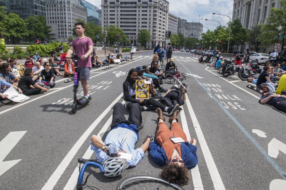 People lie on the Pennsylvania Avenue bike lane in Washington, DC, on April 26, 2019. The Rally for Streets That Don't Kill People was held outside the John A. Wilson Building to call on Mayor Muriel Bowser's administration to act on safety measures for bikers and pedestrians.