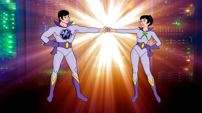 Superheroes the Wonder Twins fist-bump in front of giant computer parts.