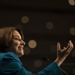 A woman gestures during a presentation.