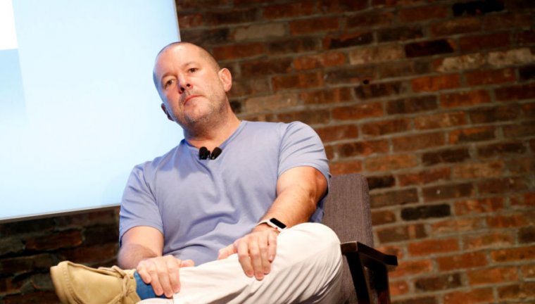 A man in a tee-shirt sits onstage.