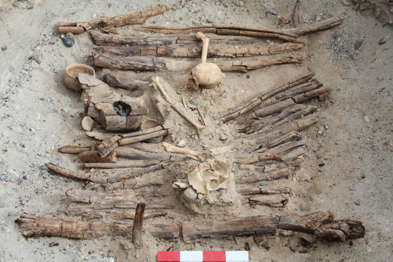 Photo of skeleton and braziers in excavated tomb.