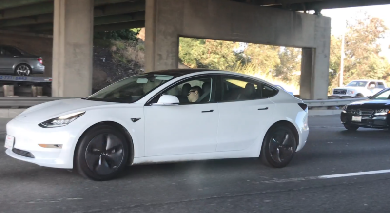 Car below an underpass with a presumably sleeping driver.