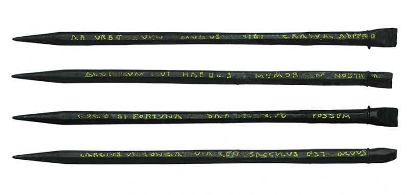 Photo of 4 sides of an iron stylus with text inscribed