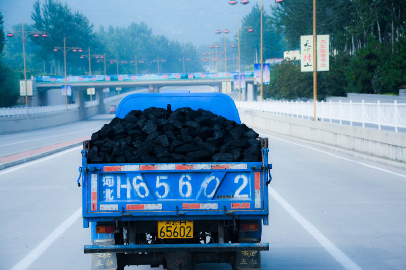 A truck filled with coal goes down a highway in China.