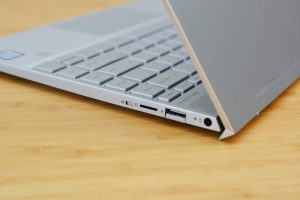 The HP Envy 13 laptop on a wooden table.