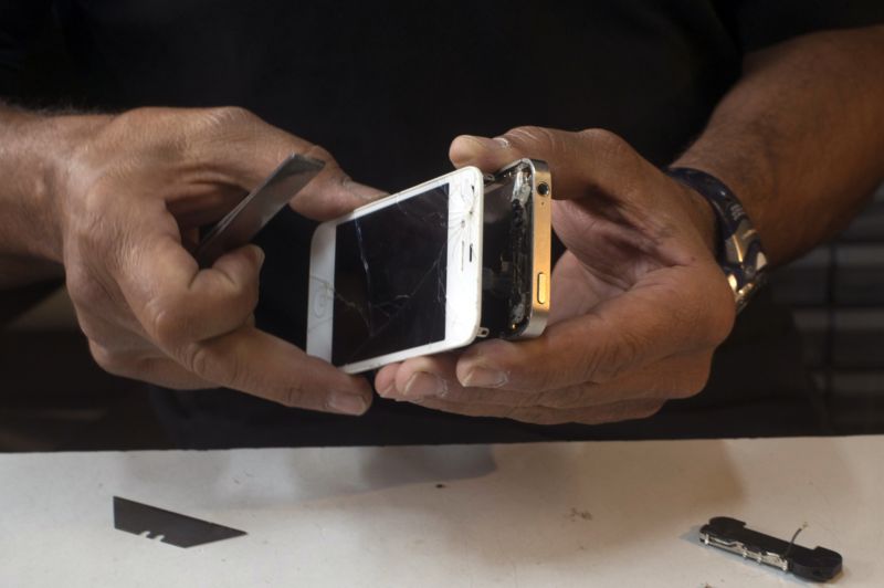 Michael Ghadieh, owner of FixMyPhoneSF, fixes an Apple Inc. iPhone in his store in San Francisco, California, USA, on August 23, 2013. Photographer: David Paul Morris / Bloomberg *** Local Caption *** Michael Ghadieh