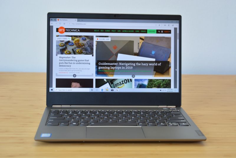 The Lenovo Thinkbook 13 laptop on a wooden table.