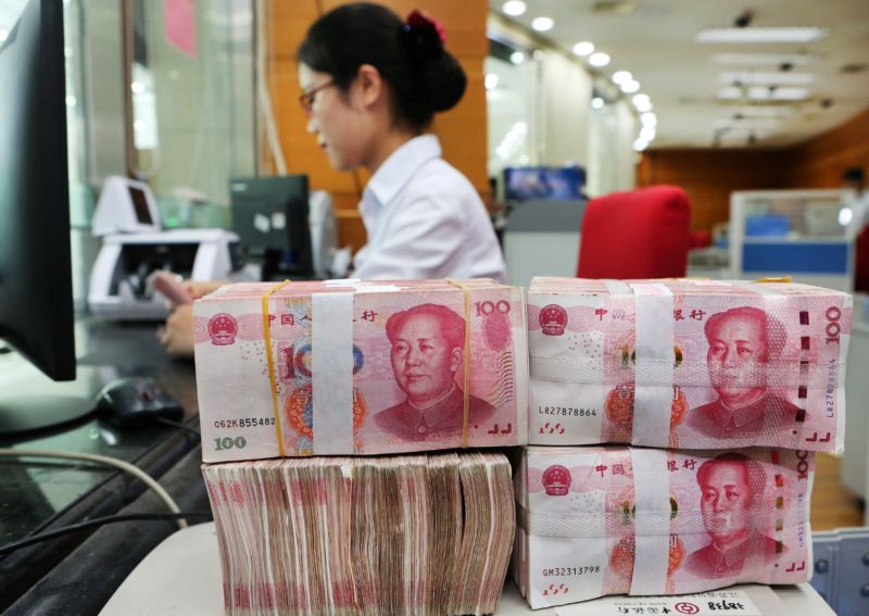 An employee counts 100-yuan notes at a bank in Nantong in China's eastern Jiangsu province on July 23, 2018.