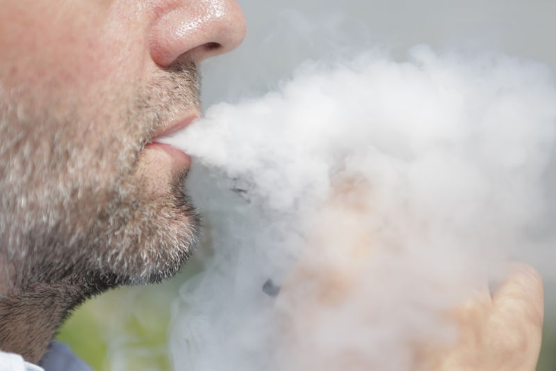 A man smokes an electronic cigarette.