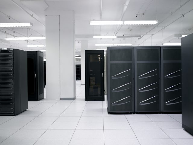 A data center stock photo. I spy with my little eye some de-badged EMC Symmetrix DMX-3 or DMX-4 disk bays at right and some de-badged EMC CX disk bays at left. Disk arrays like these are a mainstay of traditional enterprise datacenter SANs.