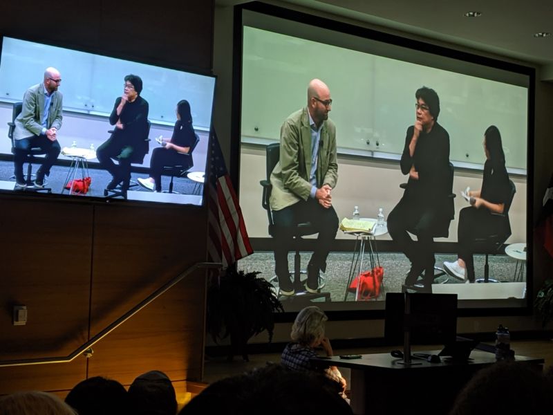 Video projection of two men giving a presentation.