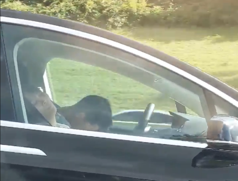 A driver and a passenger appear to be asleep in a Tesla in Massachusetts on Sunday.