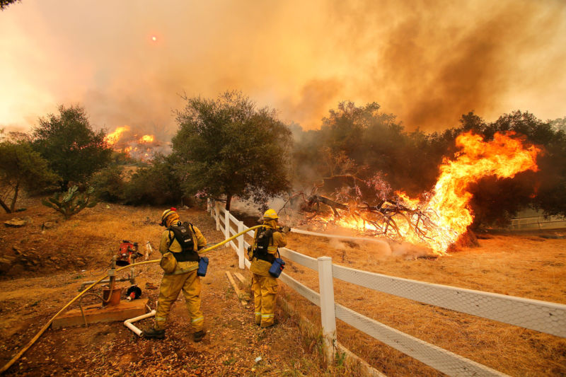 Firefighters from Stockton, Calif.,  put out flames off of Hidden Valley Rd. while fighting a wildfire, Friday, May 3, 2013 in Hidden Valley, Calif.  (AP Photo/Los Angeles Times, Mel Melcon) 