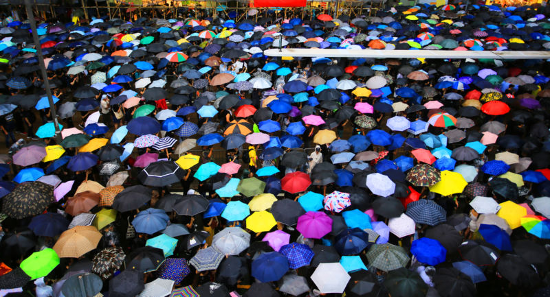 Hong Kong protestors beneath umbrellas.