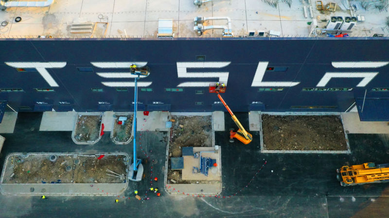 Aerial view of workers on cranes installing logo reading 'Tesla' for Tesla Gigafactory 3 at the Lingang Area on October 18, 2019 in Shanghai, China.