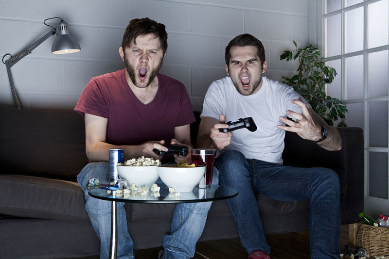 Stock photo of angry young men playing video games.