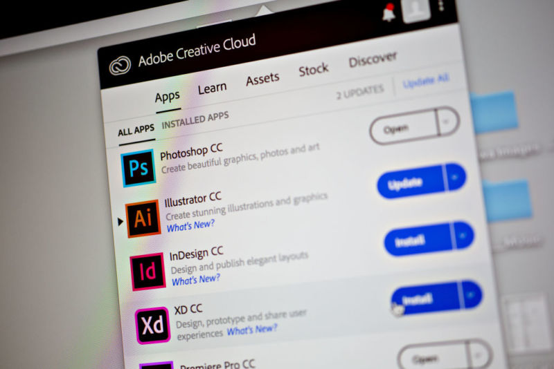 Adobe Creative Cloud application icons are displayed on a computer monitor