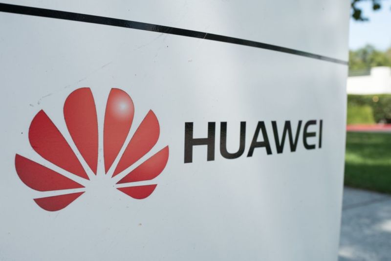 An outdoor sign with Huawei's company name and logo.