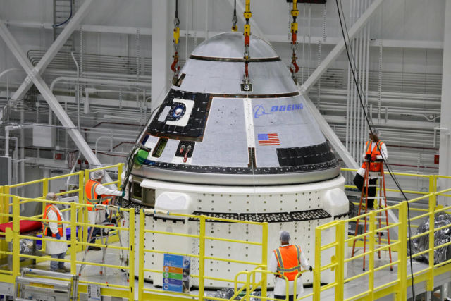 The crew module of Boeing's CST-100 Starliner spacecraft is lifted onto its service module on October 16 inside the Commercial Crew and Cargo Processing Facility at Kennedy Space Center in Florida.