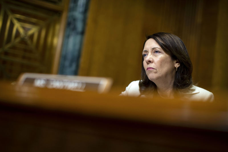 A serious woman listens during a hearing.