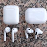 Wireless white earbuds on a marble surface.