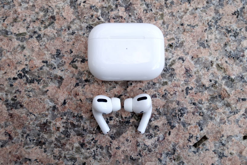 Wireless white headphones on a marble surface.