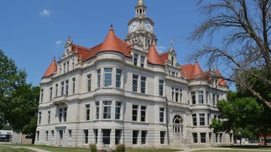Three-story courthouse with corner gables.