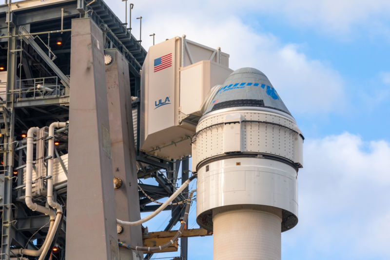 A close-up view of the Starliner capsule with its service module immediately beneath it.