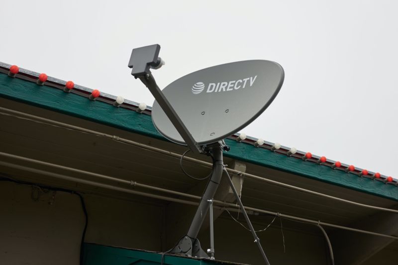 Technology A DirecTV satellite dish mounted to the outside of a building.