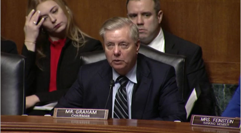 A serious man in a suit speaks during a senate hearing.