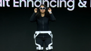 A woman shows off VR devices while onstage.