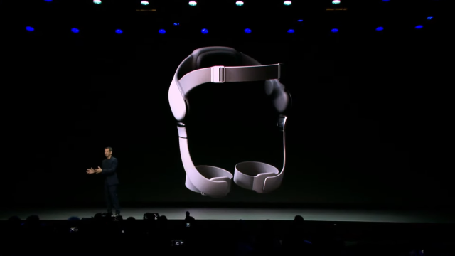 A woman shows off VR devices while onstage.