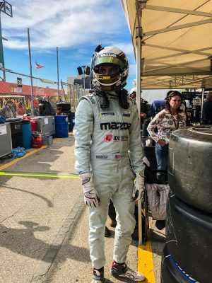 A racing driver in white overalls.