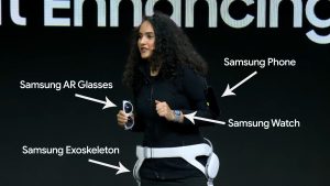 A woman shows off VR devices while onstage.