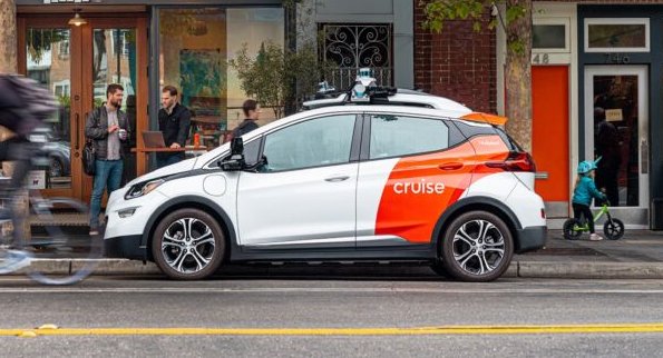 A white and red autonomous car parked on a street in San Francisco