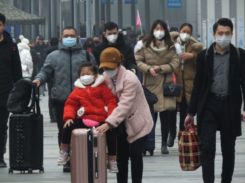 Images of people wearing respiratory masks in a Chinese railway station.
