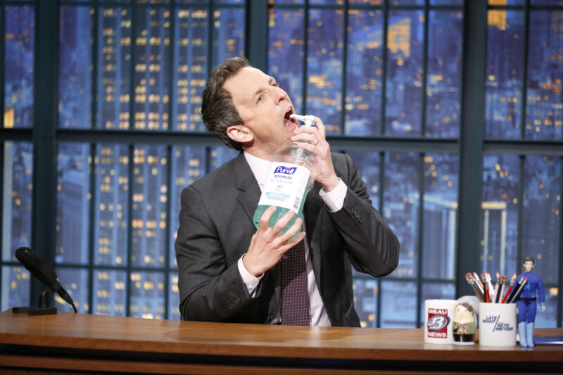 Comedian Seth Meyer sprays hand sanitizer into his mouth.