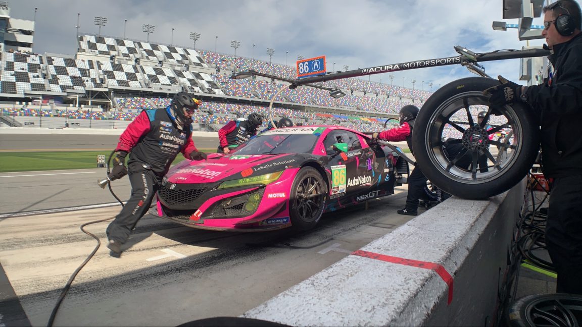 A pink race car gets its tires changed